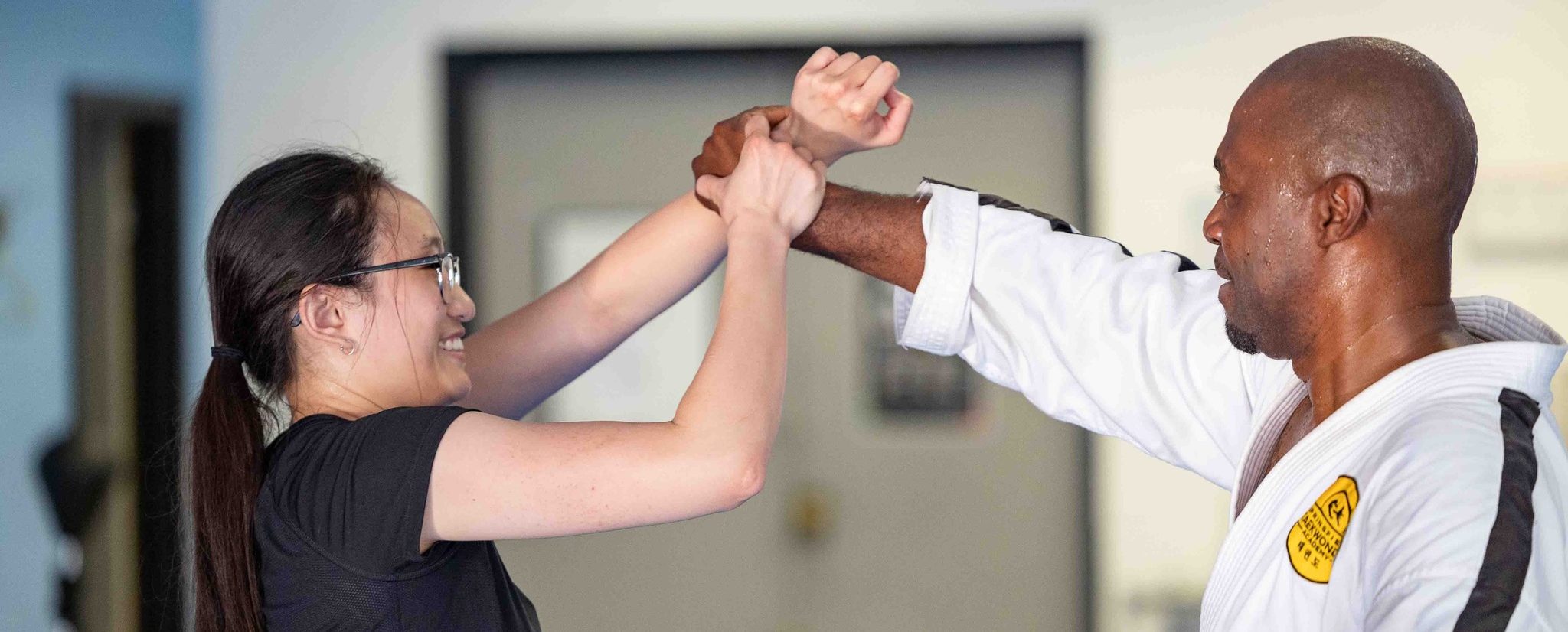 An instructor and student practicing a wrist-lock technique